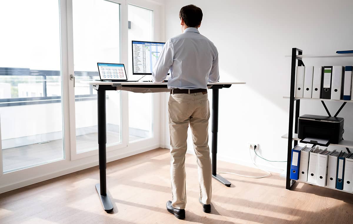 man working on computer at a standing desk