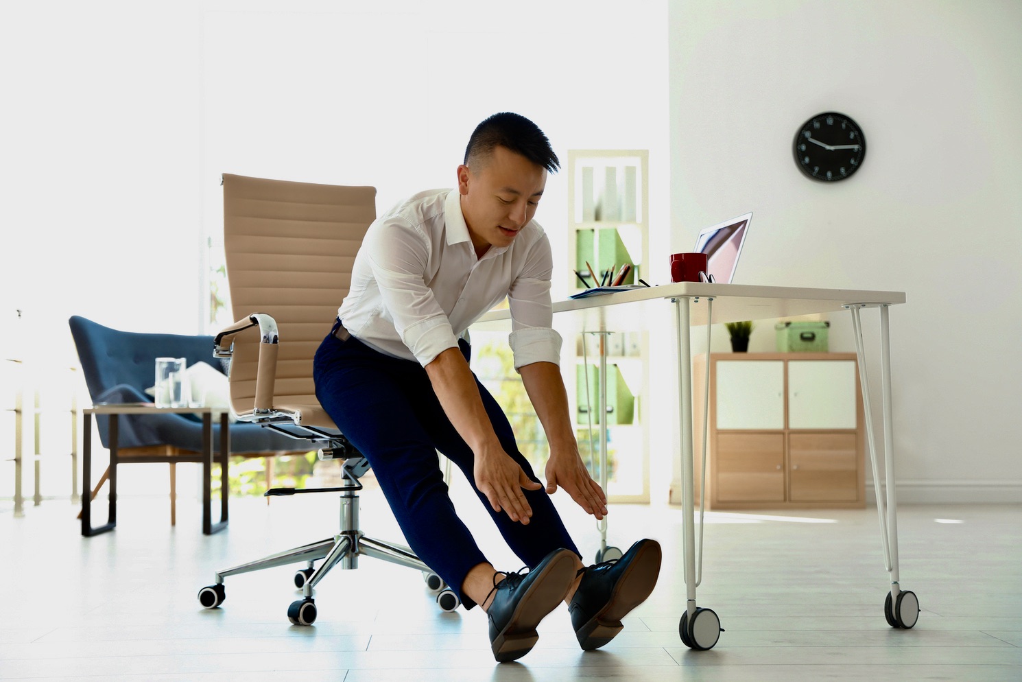 Young,businessman,stretching,in,office.,workplace,fitness