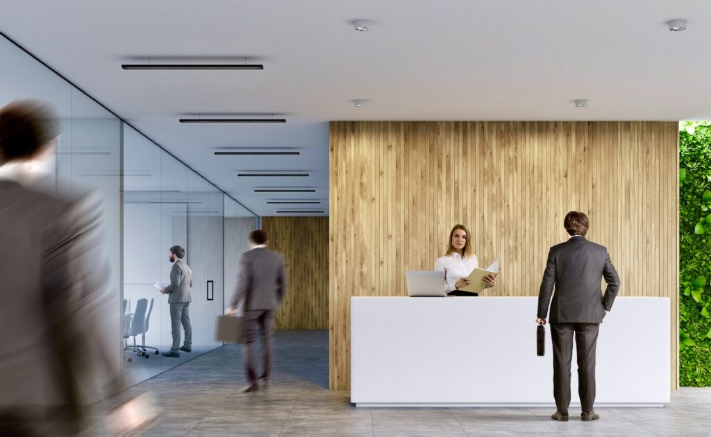 Rear,view,of,businessmen,near,a,white,reception,desk,with